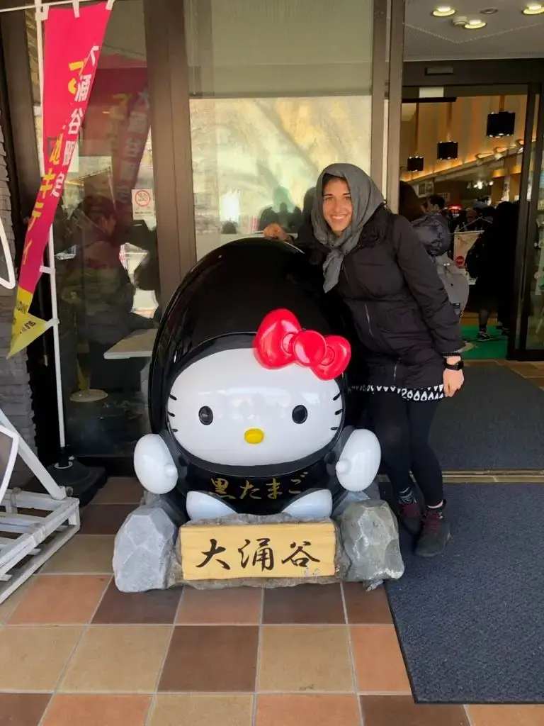 Posing with a Hello Kitty statue dressed as a black egg 