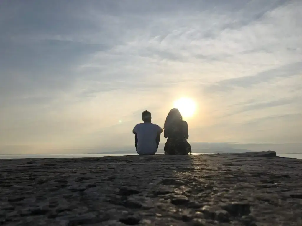 Silhouette of Man and woman sitting watching the sunset in Taketomi island