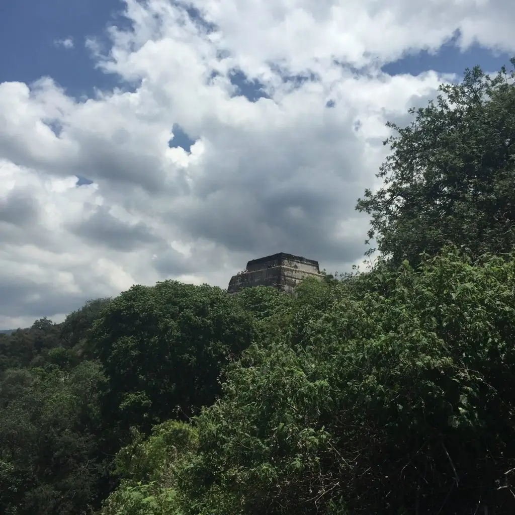 Pyramid on top of mountain surrounded by lush green vegetation in Tepoztlan