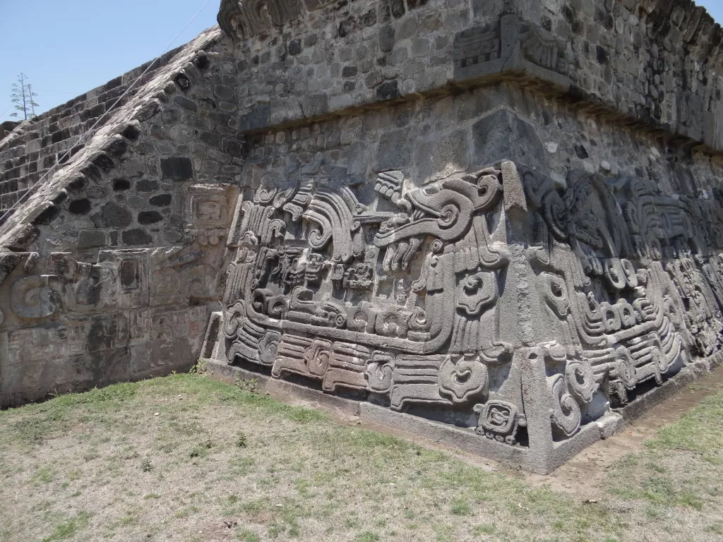 Quetzalcoatl depiction on stone on the side of a pyramid in Xochicalco