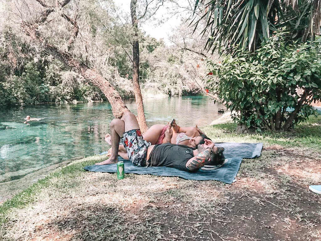A couple lounging by the river in Las Estacas when they took a day trip from mexico city