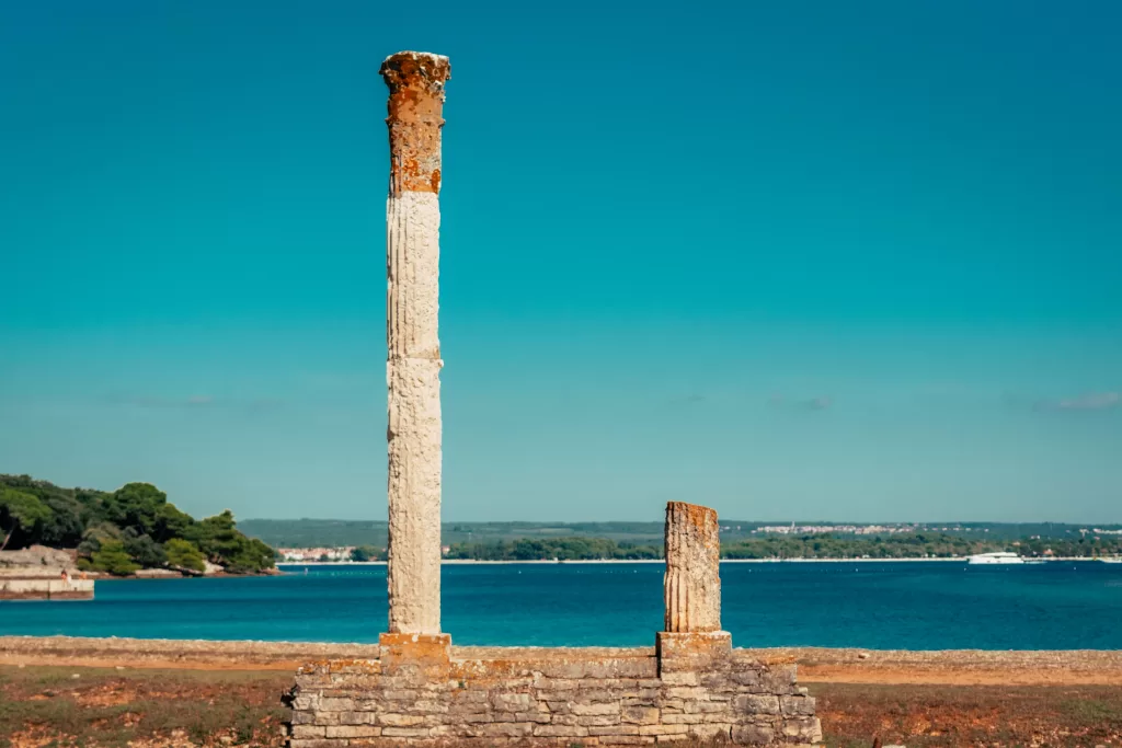 Old Roman columns overlooking the blue waters of the Adriatic Sea in Brijuni Islands, Croatia