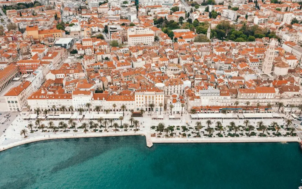 Riva promenade in Split seen from above with a quarter of the photo being blue sea