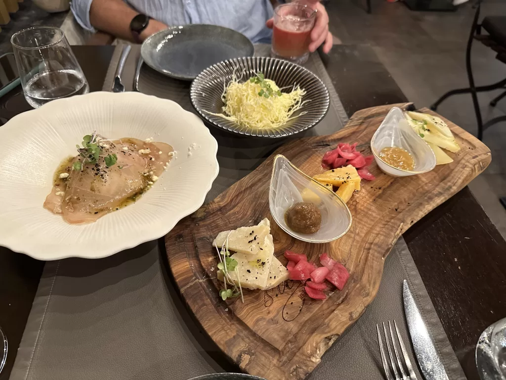 Different Dalmatian dishes on a table including a charcuterie board, a fish carpaccio and a risotto