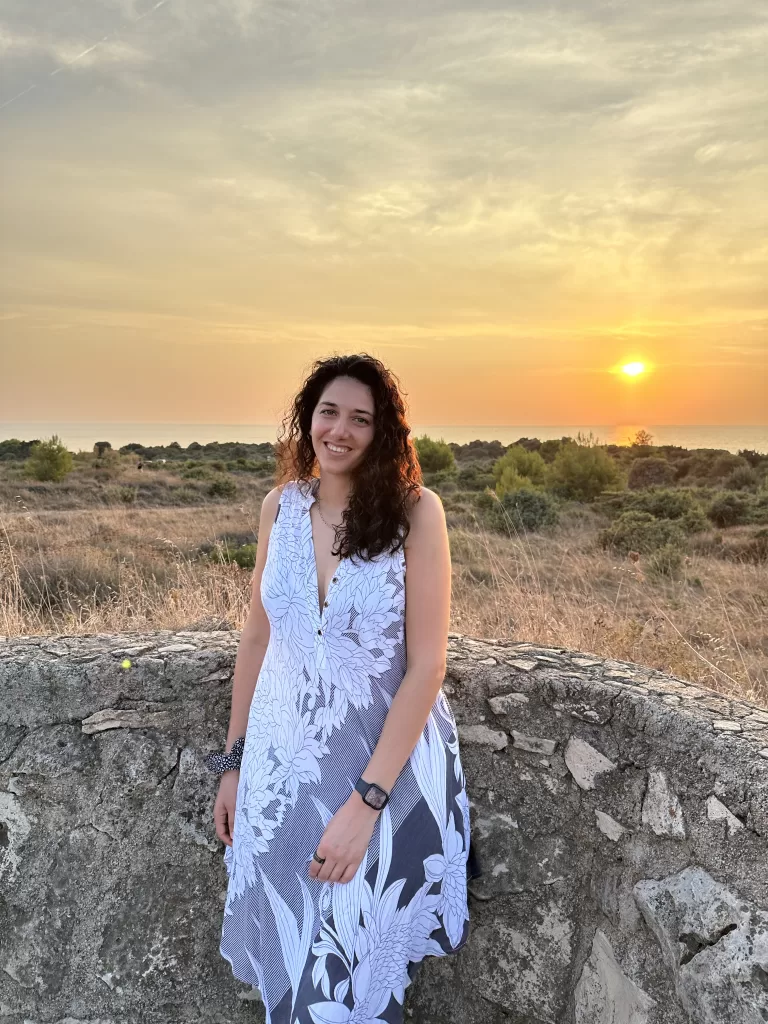Woman with a gray flower dress in Kamenjak Bunker with the sunset in the background over the Adriatic Sea