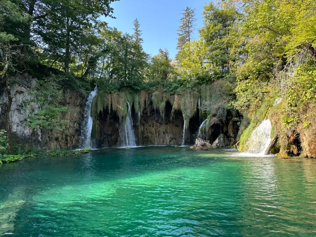 Galovacki Buk Waterfall cascading into the clear turquoise water of lake Galovac in Plitvice