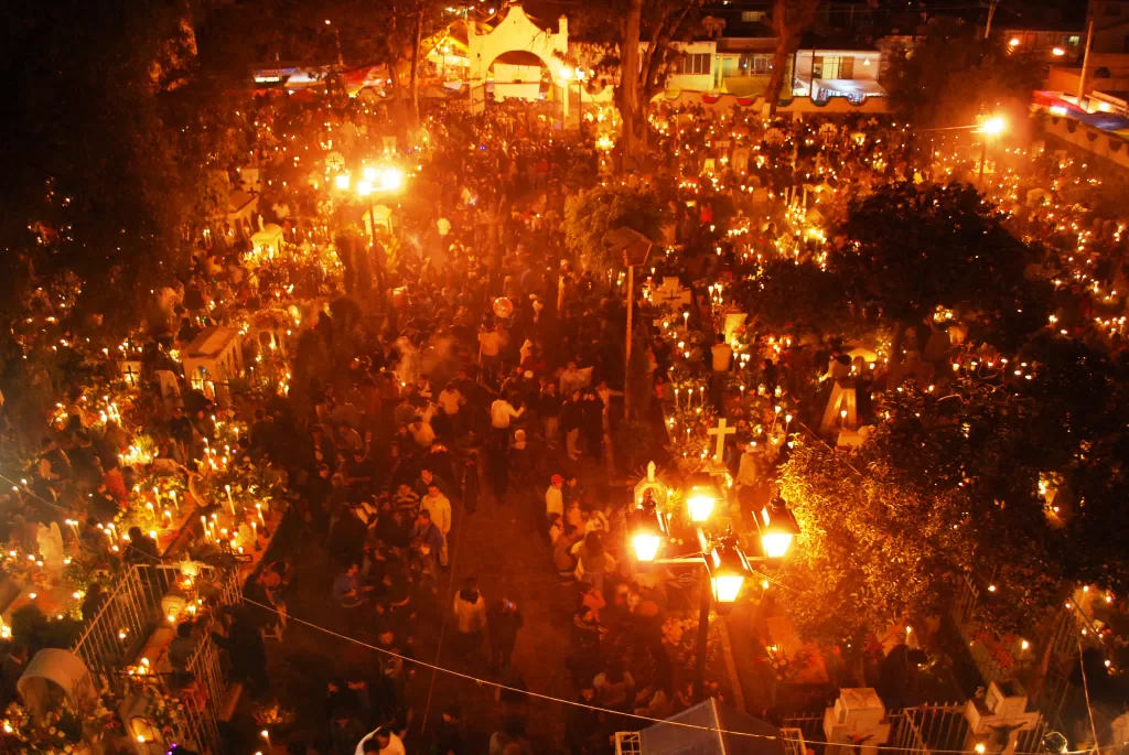 the view of mixquic cemetery from above during the Alumbrada with everything dark except tons of candles for Dia de Muertos in Mexico City