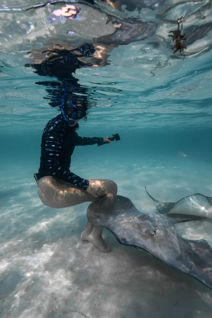 Me with a long sleeve whale shark sun suit from Waterlust with two manta rays coming up to me in the Moorea lagoon