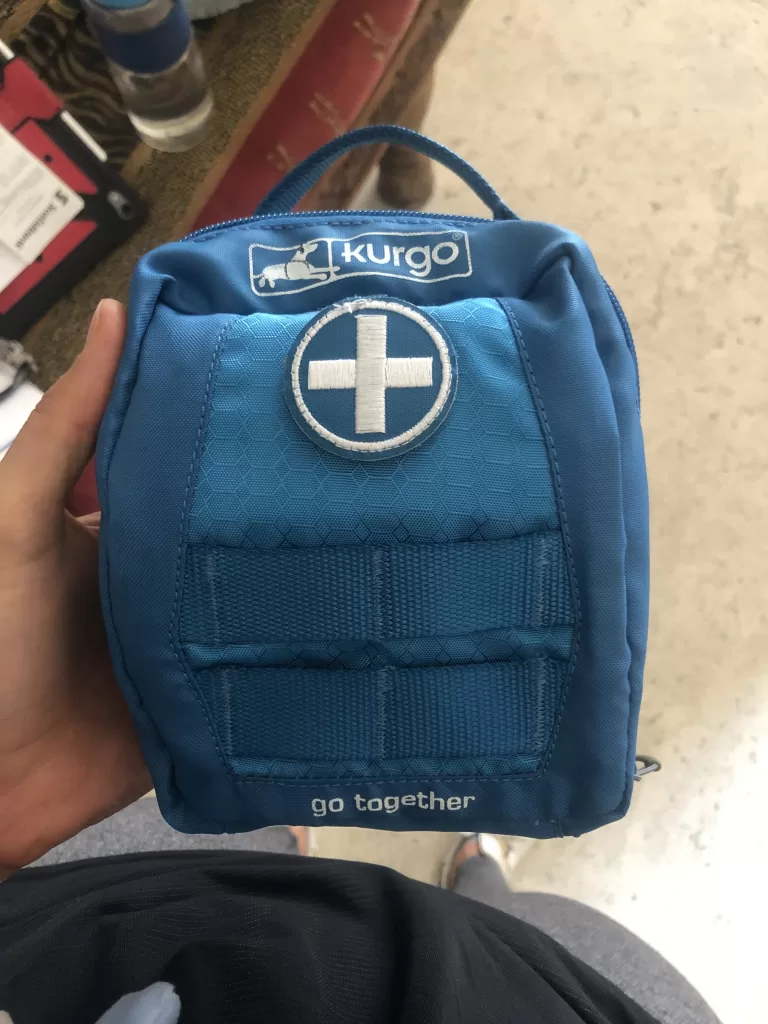 Kurgo pet first aid kit in a blue bag with white cross