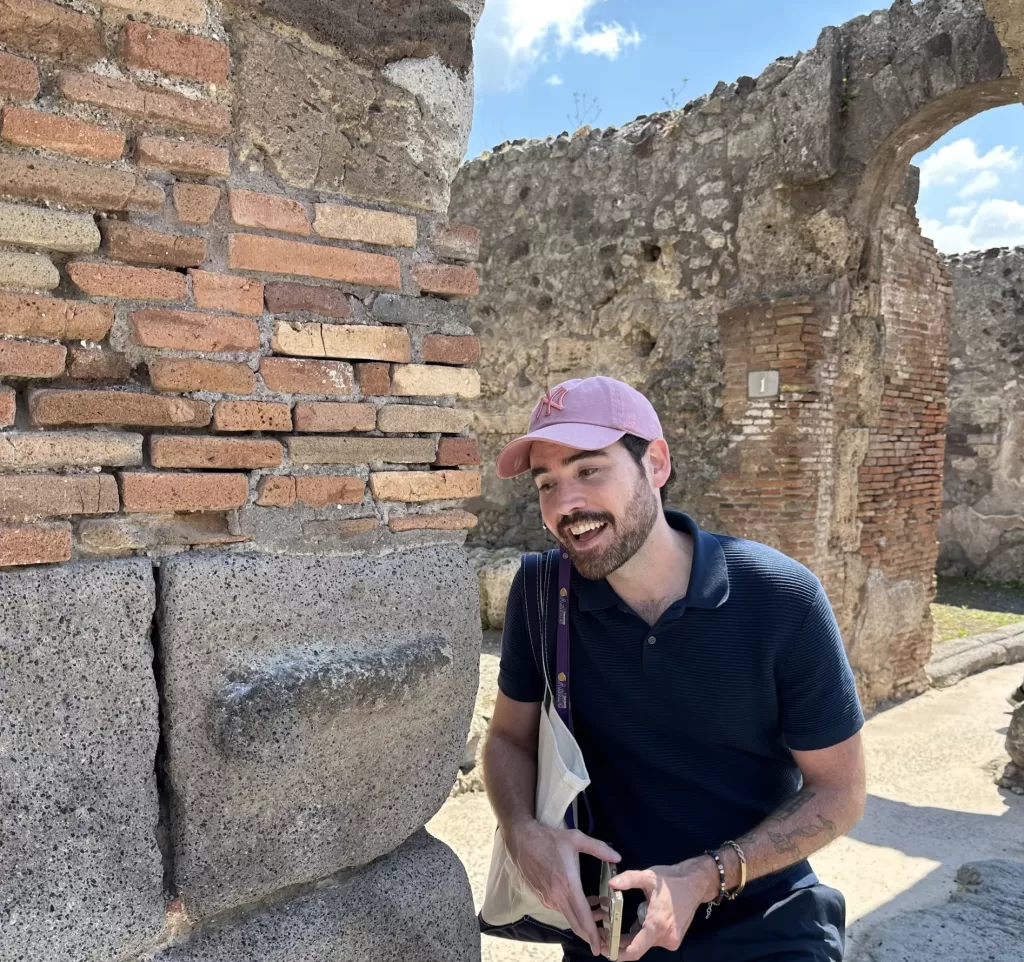 My friend Kevin posing with a stone penis in Pompeii 