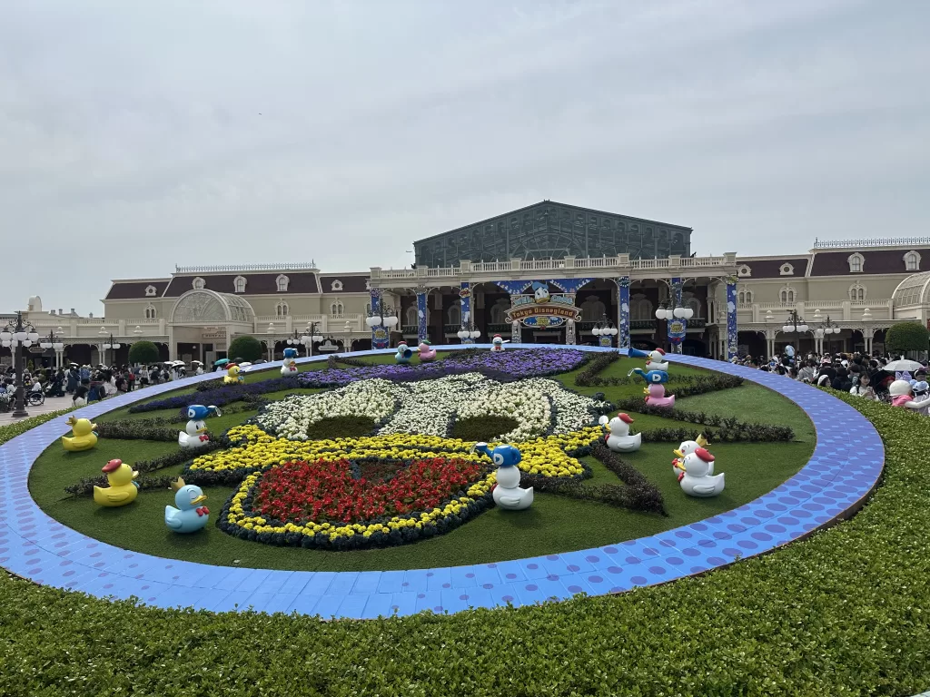 Tokyo Disneyland entrance with flowers making up Donald Duck’s face and some duckies around it